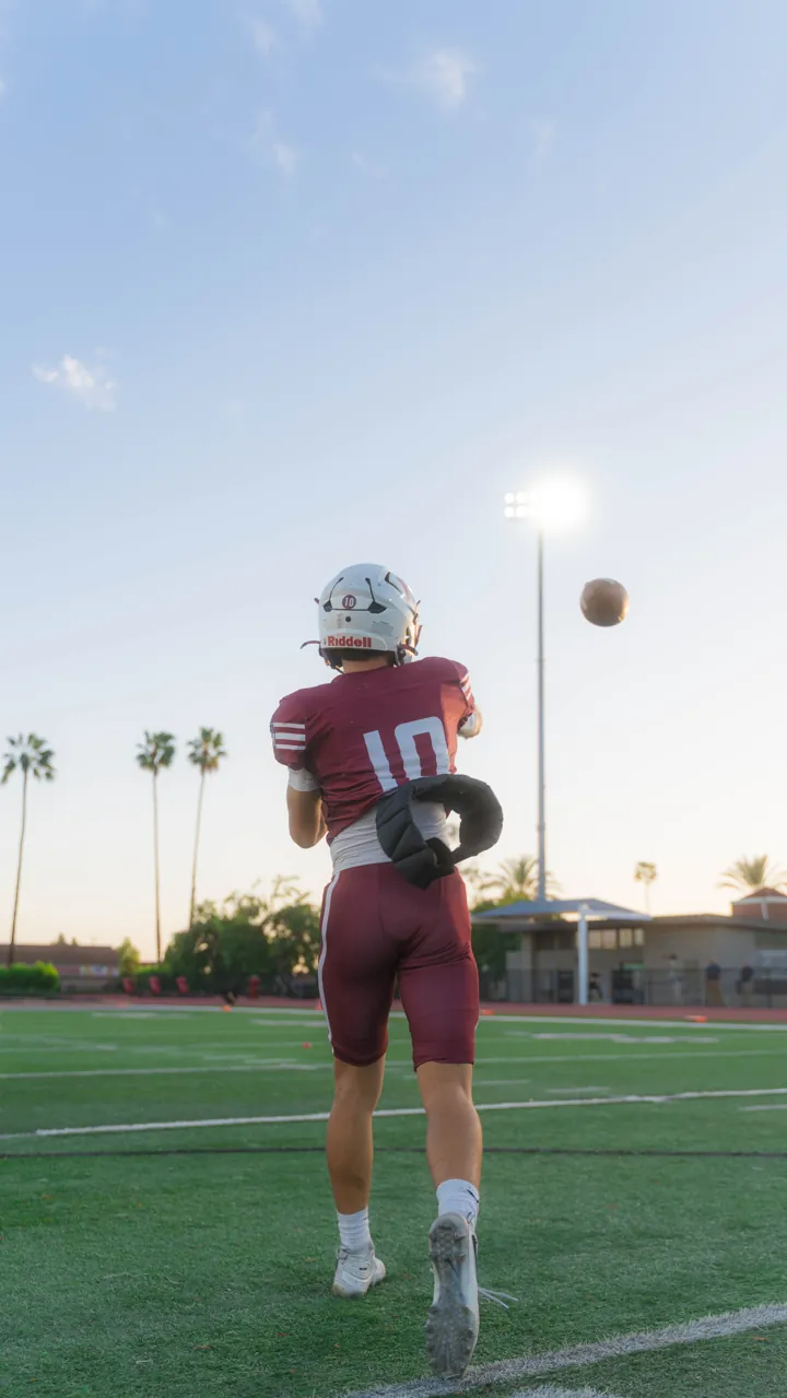 Quarterback watching a pass in the air at sunset, El Modena vs. Troy
